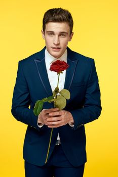 Gentlemen in classic suit on yellow background and red rose romance cropped view model portrait. High quality photo