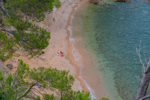 Family enoying in the Beautiful Cala Futadera beach is one of the few remaining natural unspoiled beaches on the Costa Brava, Catalonia, Spain.