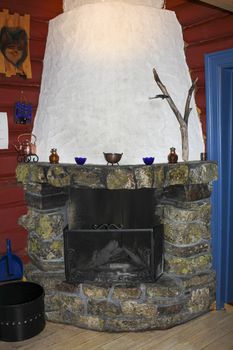 Old stone and wood fireplace in a Norwegian cabin in Hemsedal.