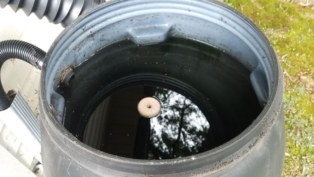 mosquito tablet insecticide floating in rain barrel with water