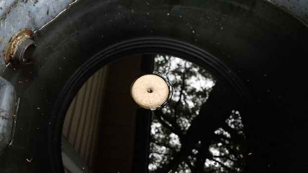 mosquito tablet insecticide floating in rain barrel with water