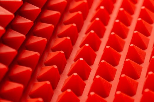 abstract red silicone pyramids mat close-up background.