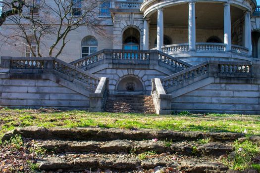 A Courtyard With Steps and a Large Balcony With Pillars Above at Elkins estate