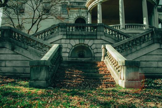 A Courtyard With Steps and a Large Balcony With Pillars Above at Elkins estate