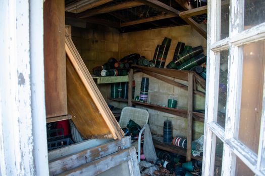 An Abandoned Store Room For a Greenhouse Full of Empty Pots and Garbage