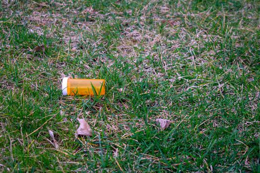 An Orange Prescription Pill Bottle in a Field of Green Grass