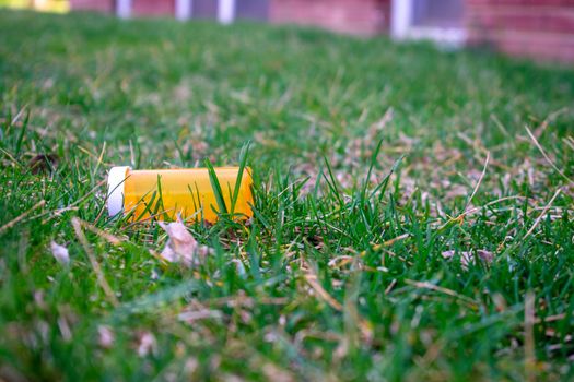 An Orange Prescription Pill Bottle in a Field of Green Grass