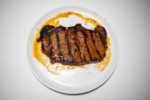 A Perfectly Cooked Steak With Grill Lines Plated on a Pure White Background