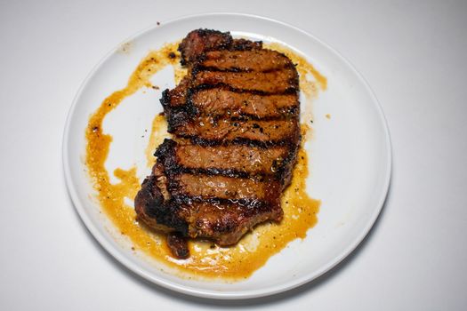 A Perfectly Cooked Steak With Grill Lines Plated on a Pure White Background