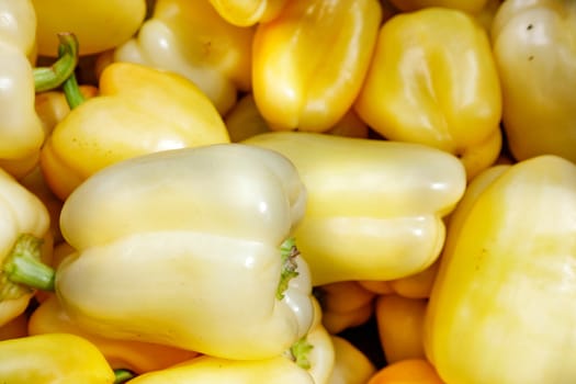 Sweet yellow ripe peppers on the market counter, background and texture, selective focus.