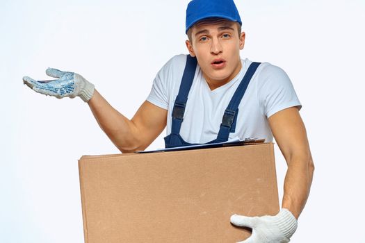 Man worker with box in hands delivery loading service work light background. High quality photo