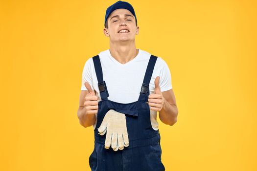 Man in working uniform emotions rendering service delivery service yellow background. High quality photo