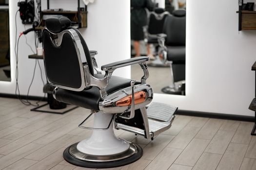 Classic vintage barber chair stands opposite mirror stylish white barber shop interior Man hairdresser salon Empty retro armchair in barbershop Professional hairstylist workplace Nobody Copy space