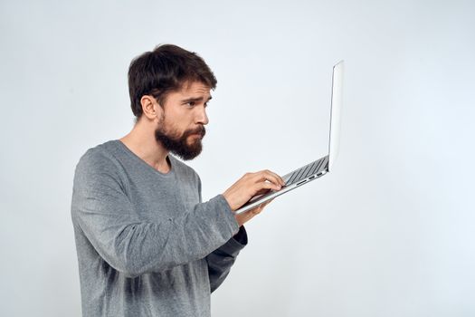 Bearded man with laptop in hands internet communication technology light background. High quality photo