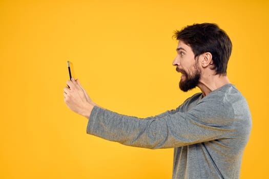 Bearded man with tablet in hands technology work wireless device yellow background. High quality photo