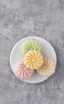 Colorful snow skin moon cake, sweet snowy mooncake, traditional savory dessert for Mid-Autumn Festival on gray cement background, top view