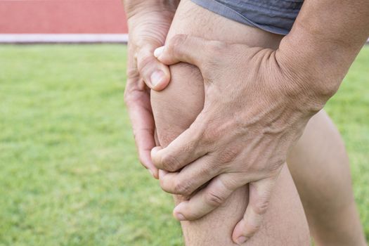 Tendon knee joint problems on Man leg from exercise In the stadium.  
