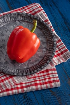 Fresh red paprika in rustic style on a blue wooden background.