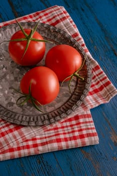 Fresh tomatoes in rustic style on a blue wooden background.