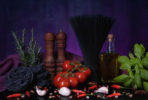 Various pasta and with herbs, spices condiments on black purple background. Cooking concept.