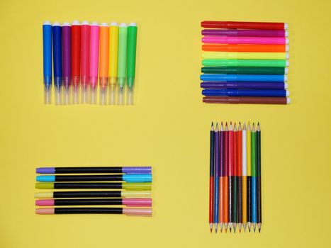 multicolored markers on a yellow background