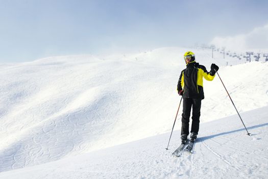 Skier standing alone and looking at panoramic view at Alps mountains ski resort copy space for text