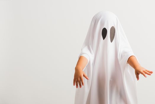 Funny Halloween Kid Concept, little cute child with white dressed costume halloween ghost scary, studio shot isolated on white background