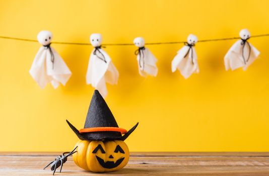 Funny Halloween day decoration party, Baby cute white ghost crafts scary face hanging and halloween pumpkin head jack lantern smile and spider on wooden, studio shot isolated, Happy holiday concept