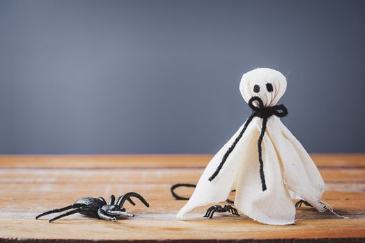 Funny Halloween day decoration party, closeup white ghost and spider on wooden wall gray background and copy space, studio shot isolated, Happy holiday concept