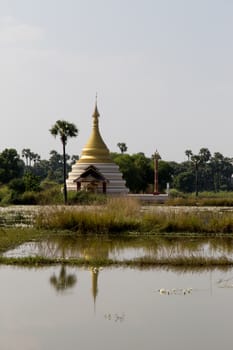 Inwa Island, Mandalay, Myanmar, stupa and temple in landscape reflected in water. Pagoda on Inwa island at Ayeyarwady River near Amarapura, Myanmar, Burma High quality photo