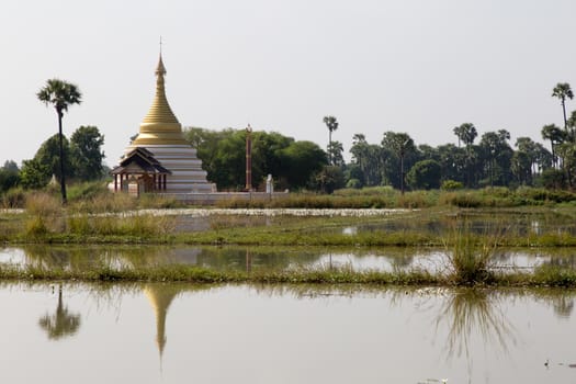 Inwa Island, Mandalay, Myanmar, stupa and temple in landscape reflected in water. Pagoda on Inwa island at Ayeyarwady River near Amarapura, Myanmar, Burma High quality photo