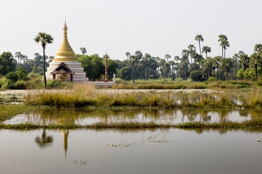 Inwa Island, Mandalay, Myanmar, stupa and temple in landscape reflected in water. Pagoda on Inwa island at Ayeyarwady River near Amarapura, Myanmar, Burma High quality photo