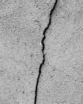 Black and white texture of a concrete wall or cement with a crack.