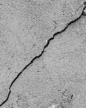 Black and white texture of a concrete wall or cement with a crack.