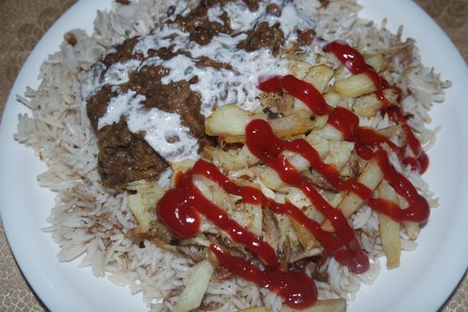 Delicious traditional dish of rice with potato fries and cereals with red ketchup. Food background with copy space for text and advertisements.