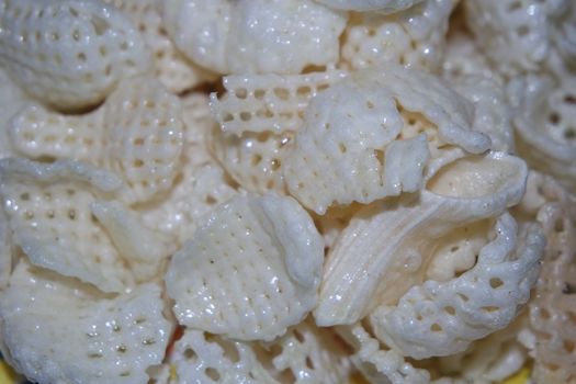 Closeup view of freshly fried chips as fast food for tea break. Potato chips with spices sprinkled on it. Fast food background for advertisements.