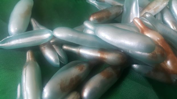 Colorful shiny bright oil capsule spread over a green background. Olden opaque oil capsules.