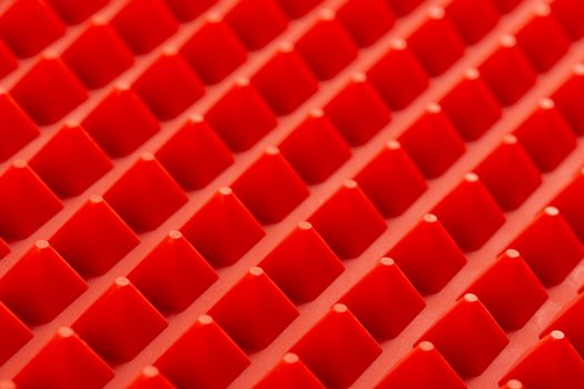abstract red silicone pyramids array close-up background.