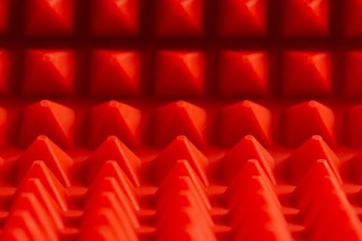 abstract red silicone pyramids mat close-up background.