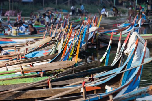 Colourful boats moored at Taungthaman Lake near Amarapura in Myanmar by the U Bein Bridge . High quality photo