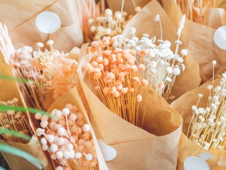 Dried grass in craft paper. Natural decorations wrapped in brown paper like bouquets. Florist store. Flower shop.