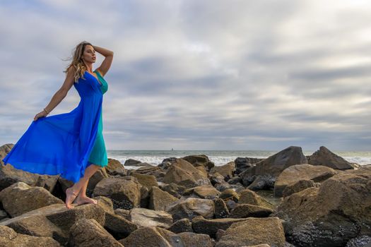 A beautiful brunette hispanic model posing outdoors on a beach at sunset