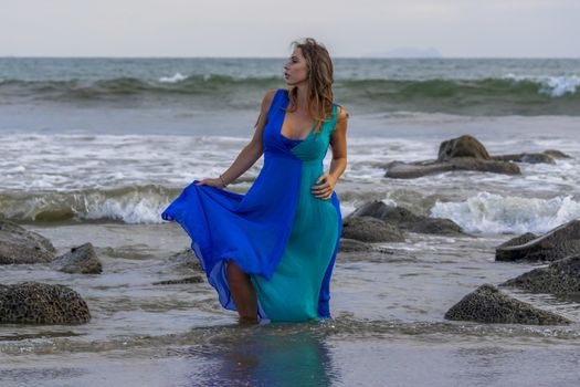 A beautiful brunette hispanic model posing outdoors on a beach at sunset