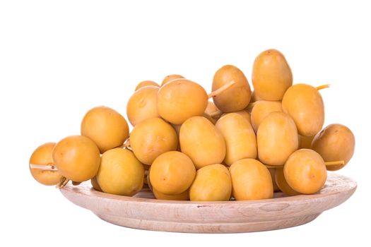 Dates or date palm in wood bowl isolated on white background.