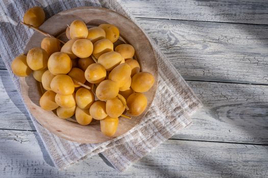 Dates or date palm in wood bowl on wooden background. Healthy fruit.