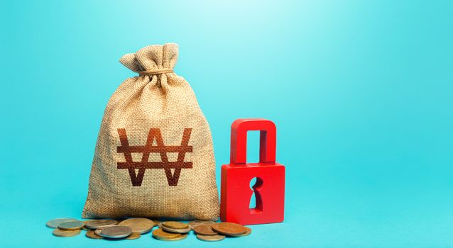 South korean won money bag and red padlock. Blocking bank accounts and seizing assets. Tight government control over the financial system. Cash flow monitoring. Freezing of pension savings.