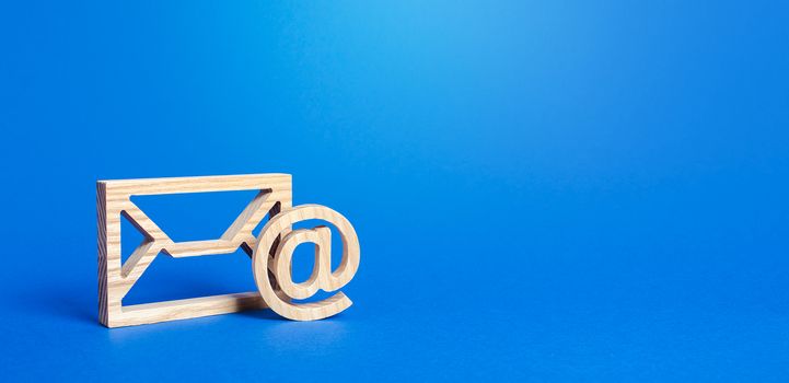 Email figure on blue background. Envelope and AT commercial sign symbol. Concept of email address. Contacts and communication. Business representations on the Internet and social media. Feedback