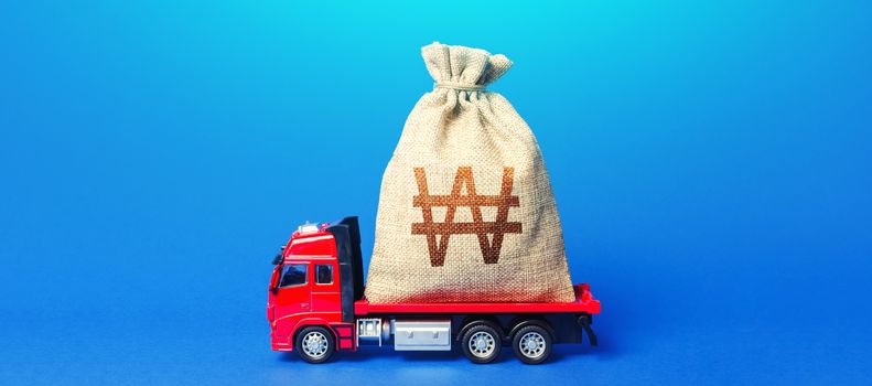 Truck is carrying a huge south korean won money bag. Anti-crisis measures of government. Great investment. Attracting large funds to economy for subsidies, support and cheap soft loans for businesses.