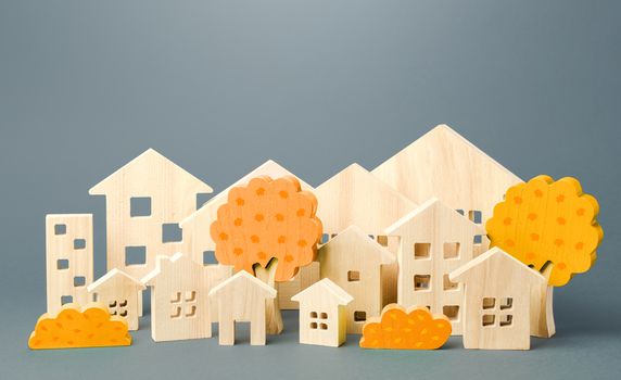City of figures houses and autumn yellow trees. Real estate concept. Urbanism and infrastructure. Realtor services. Affordable housing. Changing seasons. Travel and tourism in the cities of the world.