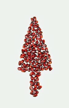 Beautiful christmas tree made with red pomegranate seeds on white background